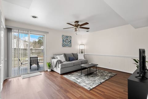 Relax in the plush living room with a flat-screen Roku Smart TV and easy access to the back patio through a sliding glass door.