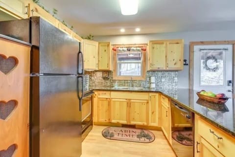 Bright kitchen featuring wood cabinetry, granite countertops, and bar seating for casual meals after a fun day of hiking.