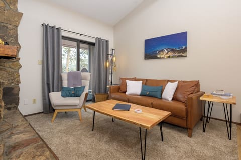Unwind in your stylish living space featuring rich leather seating, warm wood accents, and a cozy stone fireplace perfect for relaxing evenings.