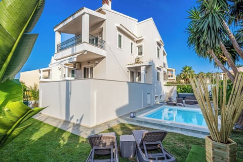 "Welcome to House Anastasia! A tranquil retreat nestled amidst lush greenery and a sparkling pool."