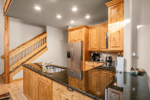 Open concept kitchen area. Beautiful kitchen with all stainless steel appliances, plenty of counter space. Stairs up to the upper level bedrooms and loft.