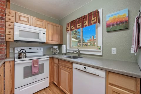 Your Vacation House Estes Park, Kitchen with glass top electric stove/oven with microwave range hood, sink, and dishwasher.