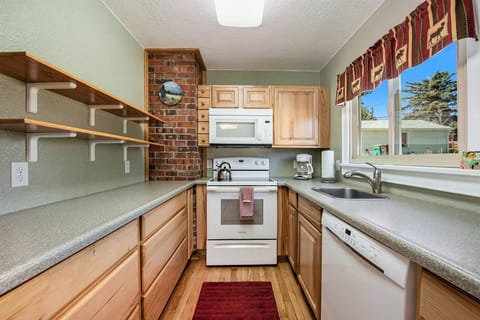 Your Vacation House Estes Park, Kitchen with glass top electric stove/oven with microwave range hood, sink, dishwasher, and lots of shelf space.