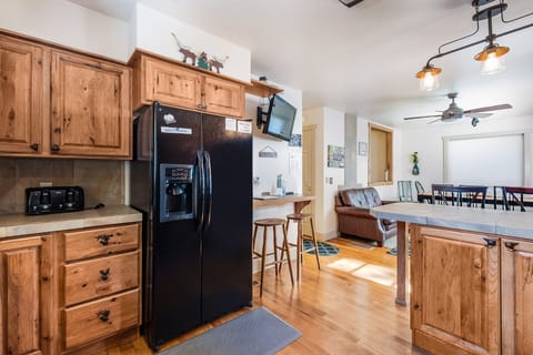 Full refrigerator with water and ice dispenser. A small wall mounted Tv for entertainment.