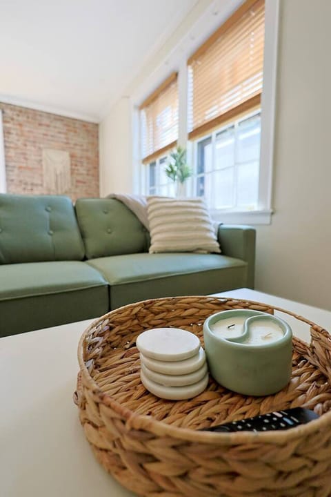 Living Room Oasis: Bright space with a chic green sofa and warm, inviting decor for relaxation!