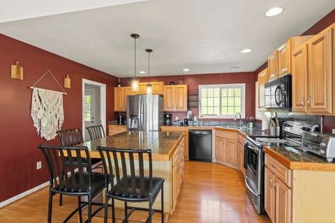 Cook up a storm in this spacious kitchen with modern appliances and a breakfast bar, all set against warm, inviting colors. A culinary delight!
