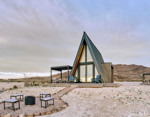 Exterior view of A-Frame #3 front bedroom windows, fire pit and the wrap-around deck