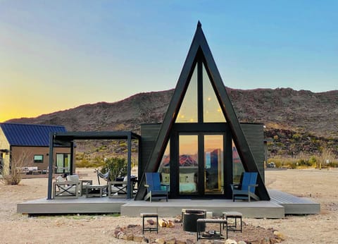 Exterior view of A-Frame #1 front bedroom windows, fire pit and the wrap-around deck