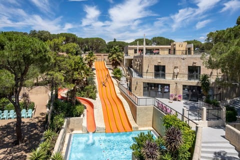 Experience the rush down the vibrant orange water slide, perfect for a day of fun in the sun.