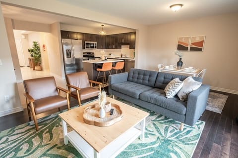 Bright and cozy living space with mid-century modern furniture, large French doors leading to a private patio, and an open layout. Perfect for relaxing or hosting, with vibrant decor, natural light, and a welcoming ambiance. Ideal for any stay!