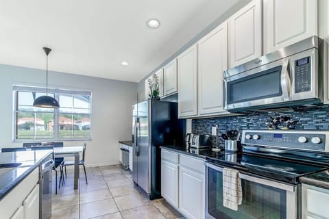 Fully equipped kitchen with stainless steel appliances, ample counter space, and modern design.