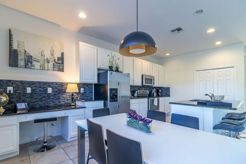 Fully equipped kitchen with modern appliances and breakfast bar seating.
