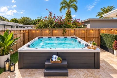 Room for the whole crew! Oversized hot tub seats up to 12 with dozens of jets, easy-access steps & a fully fenced, private yard. Relax together after the beach as the string lights glow at sunset. Towels ready