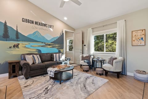 Relax in a comfortable living space with seating for four, perfect for unwinding after full days in Yellowstone. A hand-painted mural brings the landscape indoors, inspired by the park's wildlife and scenery.