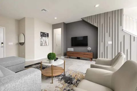Modern living room with sleek design, smart TV, and cozy seating for all.