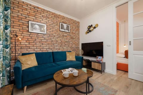 The exposed brick wall, navy-blue sofa and wooden coffee table create a cosy sitting area perfect for unwinding in the evening.
