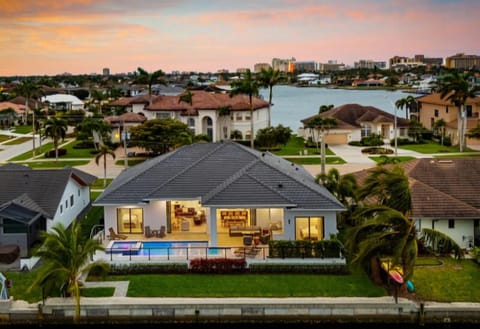 Exterior Oasis: Sunset hues illuminate this beautiful home with pool and bay views on sunny Marco Island!