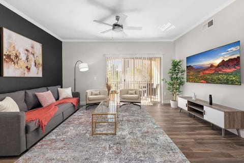 Living area with sofa, chairs, table and TV