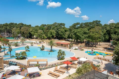 Relax in the spacious pool area surrounded by lush greenery, the perfect spot to soak up the sun and unwind.