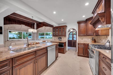 The open gourmet kitchen features bar seating for three and a pantry.