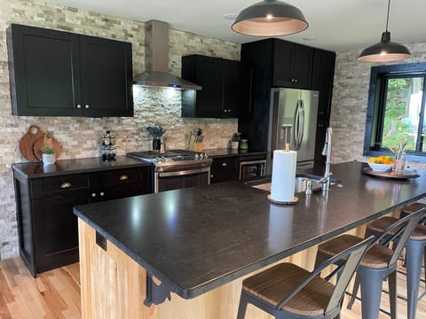 New gas range, dw, refrig, granite, stone backsplash, bar seating, beverage bar