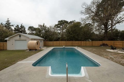 The fully fenced backyard features a private saltwater pool, relaxing outdoor sauna, fire pit, and multiple seating areas for the ultimate Wilmington getaway.