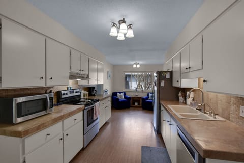 Kitchen – Stocked, Spacious, and Ready to Cook - Everything you need is right here: microwave, crockpot, full oven, and enough counter space to make real meals happen. And yes, that nook at the end is as cozy as it looks.