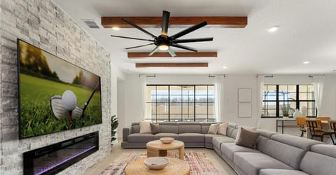 Sleek and spacious living room featuring modern furniture, indoor fireplace, and a large smart TV, perfect for relaxing or hosting a movie night in style.