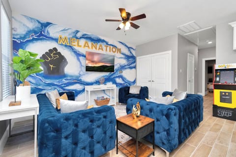 MelaNation! Living Room with 3 seater sofa, single couches and 75 inch TV