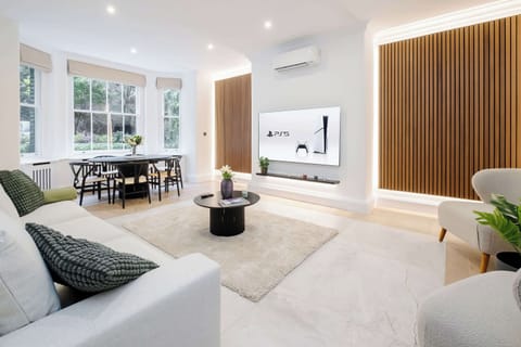 Living Room | Elevated Luxury: Spacious and elegantly decorated living room with comfortable seating, a Smart TV, and a dining table overlooking the peaceful private garden. Bright, stylish, and perfect for relaxing or enjoying meals together. 