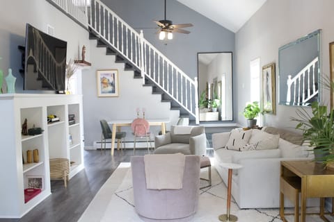 Upstairs living room, with high ceilings, natural light + comfortable furniture