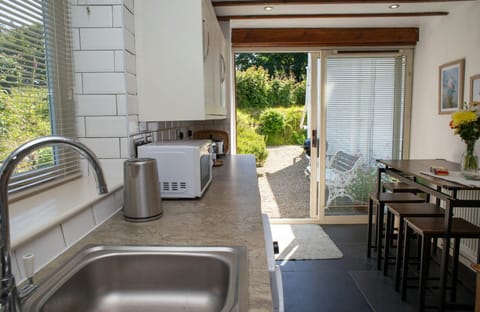 Kitchen with breakfast bar and doors leading to the garden