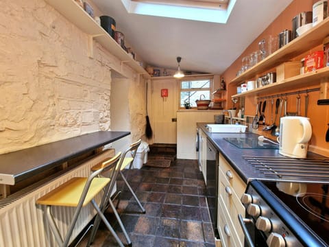 Kitchen with cooker, washing machine, dishwasher, kettle, sink, breakfast bar