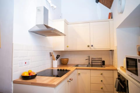 Kitchen with oven and hob, microwave, cooker hood and sink