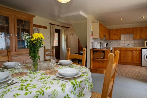 Dining area with round dining table and chairs and view of the kitchen