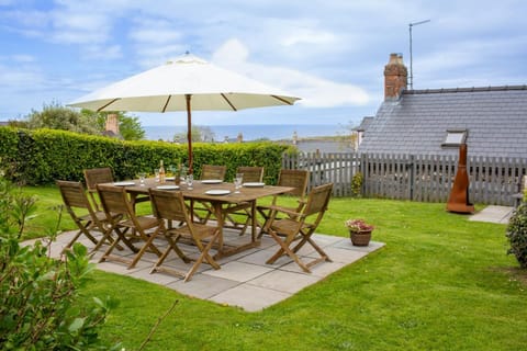Wooden table and chairs on the lawn in Bronmor's garden