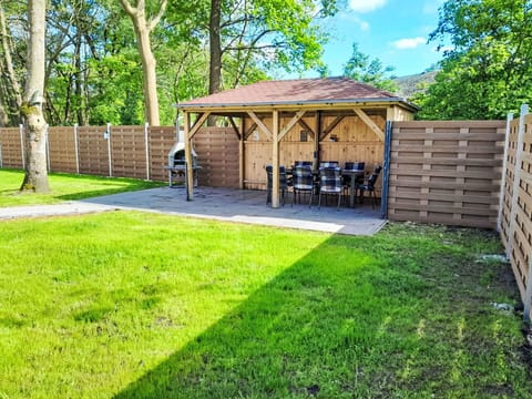 Plant, Property, Tree, Shade, Sky, Land Lot, Outdoor Furniture, Natural Landscape, Grass, Wood