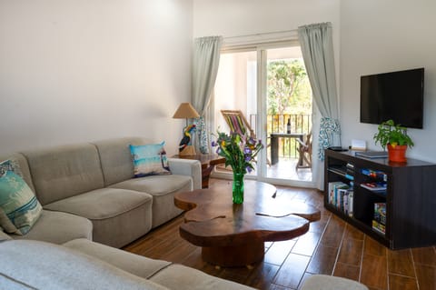 Tamarindo vacation rental condo featuring a spacious lounge with large sectional sofa, AC, and flat‑screen TV. Relax on your private balcony and enjoy comfort and style — ideal for families or groups seeking luxury vacation rentals in Costa Rica.