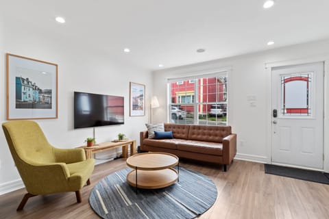 Unwind in this warm and inviting space, complete with a comfy leather sofa, vibrant accents, and plenty of natural light!