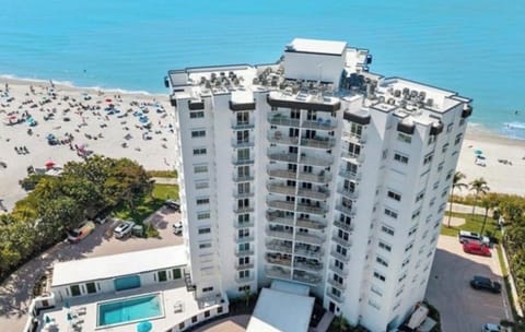 Aerial view of condo building, pool & beach