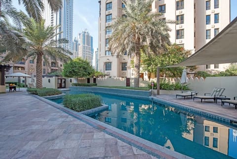 Outdoor Retreat: Swim and sunbathe with vibrant palm trees and towering skyline as your backdrop!
