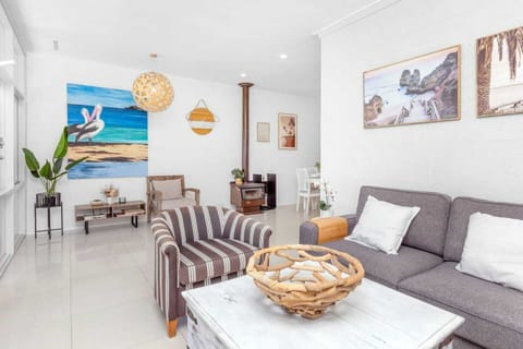 Bright and spacious open-concept living area, featuring comfortable seating, artistic decor, and a cozy fireplace for cooler evenings.