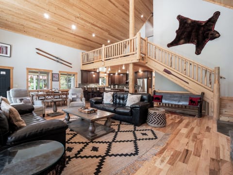 Gather in this stunning lodge-style living space, featuring cozy leather seating, vaulted wood ceilings, and a warm, inviting atmosphere perfect for making memories.