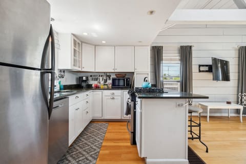 Fully equipped kitchen with all necessary appliances, 3-seater eat-in counter, and 6-person dining table