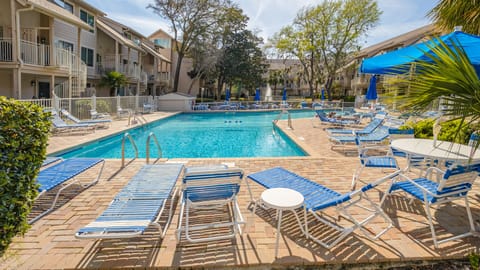 The community pool offers a resort-style setting surrounded by lush greenery and open skies—perfect for cooling off after a day at the beach.