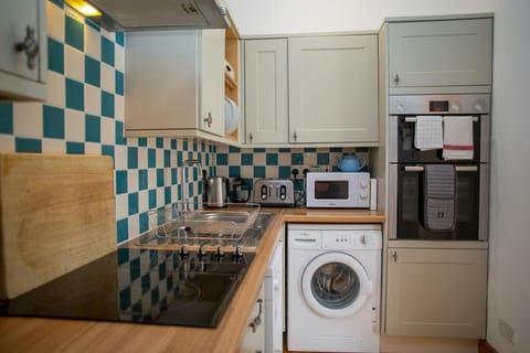 Kitchen with microwave, washing machine, electric hob and oven
