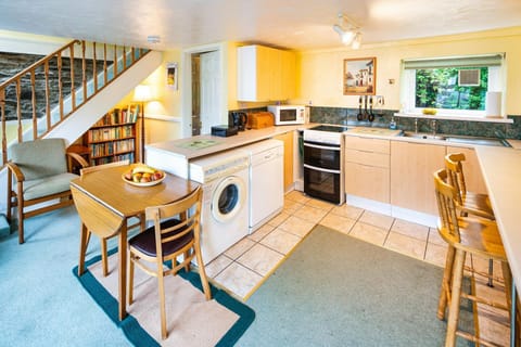 Kitchen with cooker, washing machine, dishwasher, microwave, kettle, sink, dining table and breakfast bar