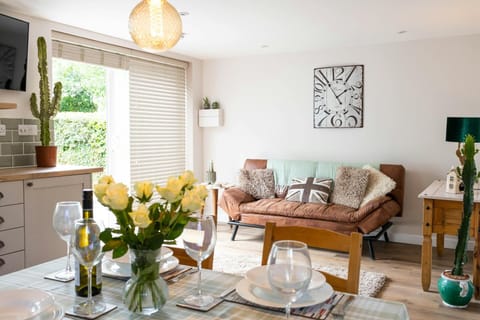 Table ready for lunch, vase of flowers, sofa, large clock