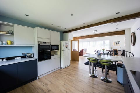 Kitchen with laminated flooring, toaster and an integrated cooker.