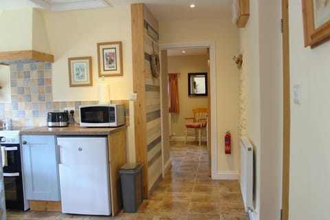 Microwave, fridge, toaster, radiator and pictures on the wall